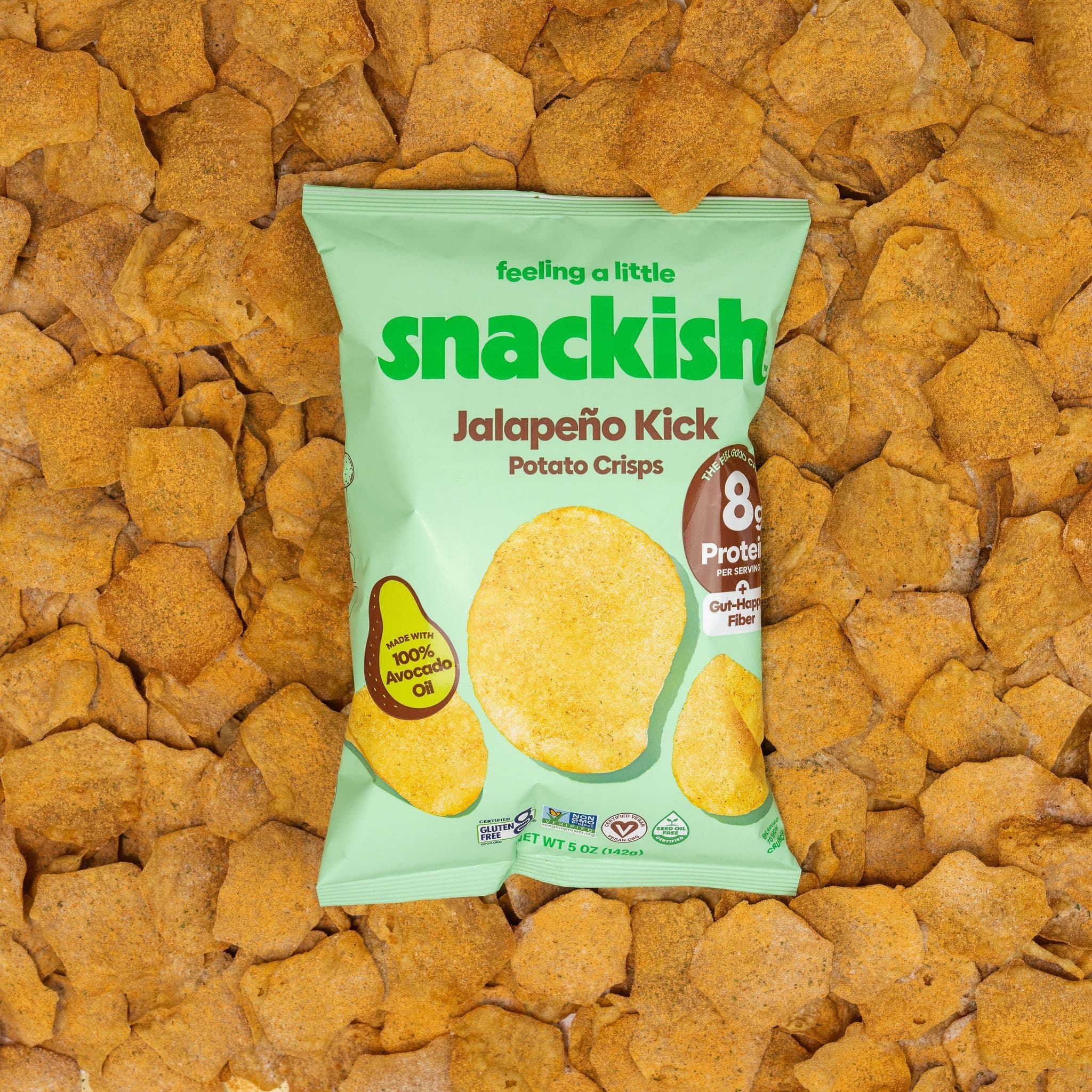 A bag of Snackish Jalapeno Kick potato crisps surrounded by golden crisps.