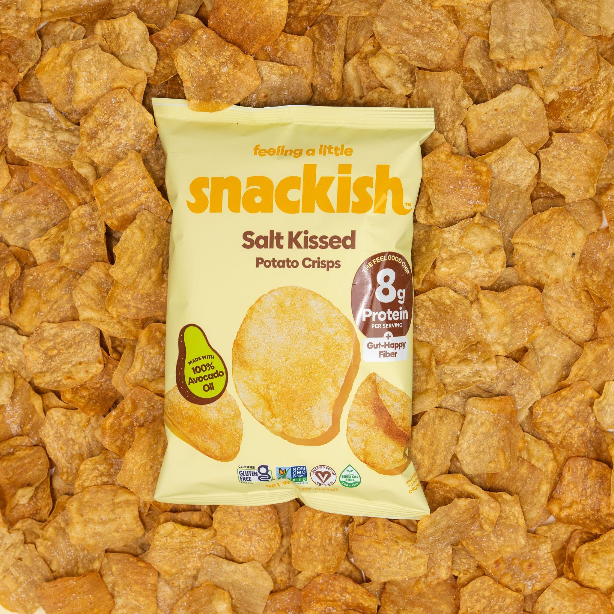 A bag of Snackish Salt Kissed potato crisps surrounded by golden crisps.