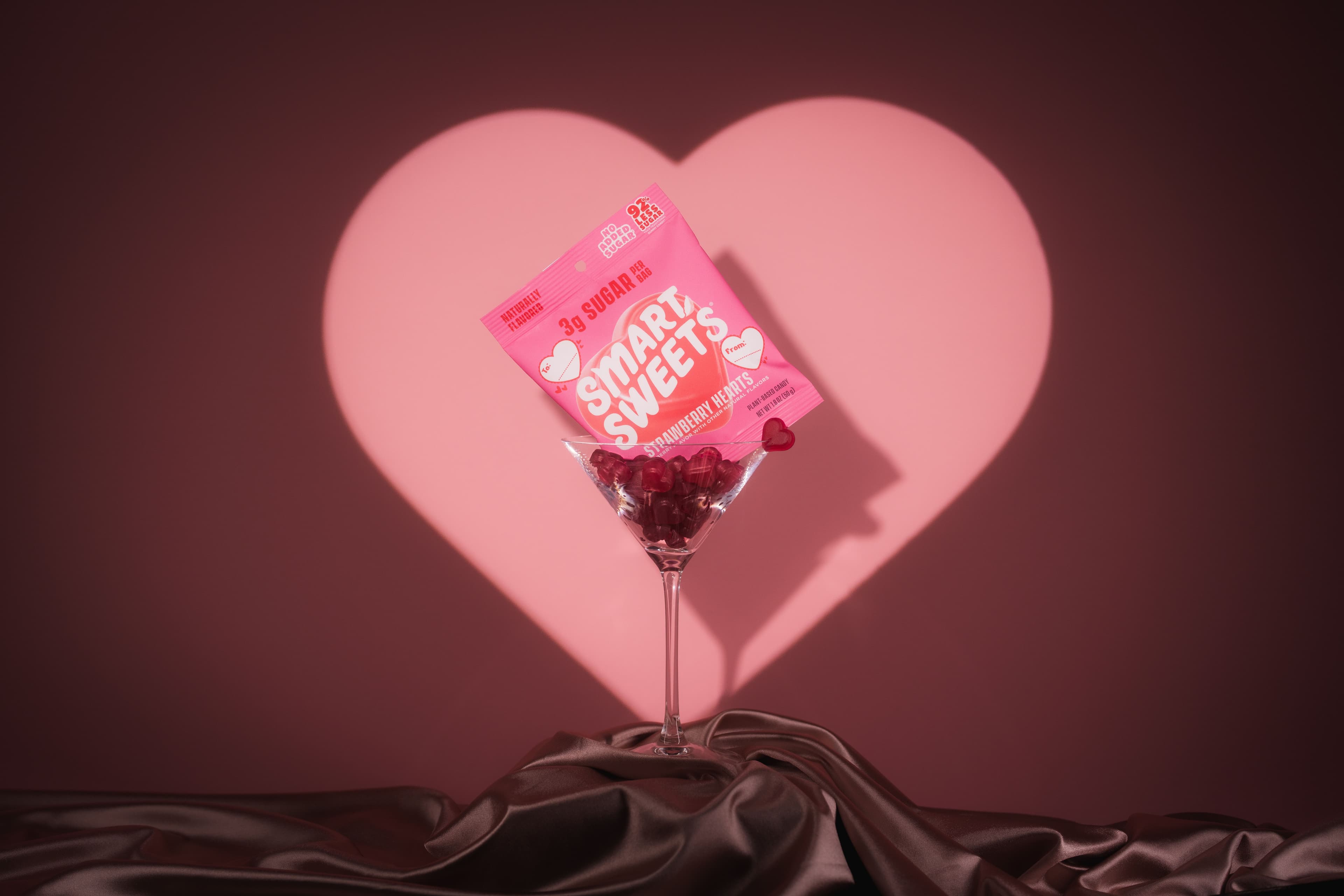 SmartSweets Strawberry Hearts highlighted by a heart-shaped pink spotlight.