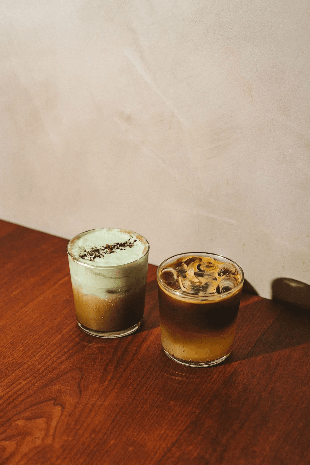 Two spring coffee drinks on a wooden table.
